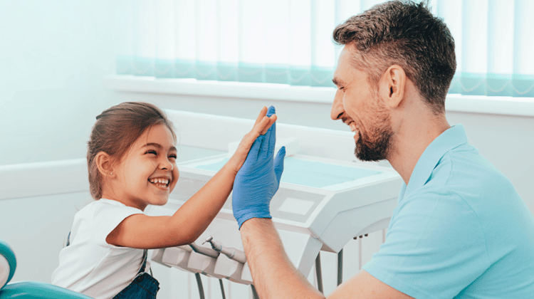 pediatric dentist high-fiving patient