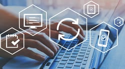 Hands typing on a laptop with digital workflow icons representing dental office software and practice management systems.