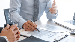 man filling out insurance policy documents