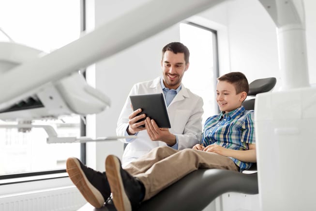 Dentist educates patient with tablet resources